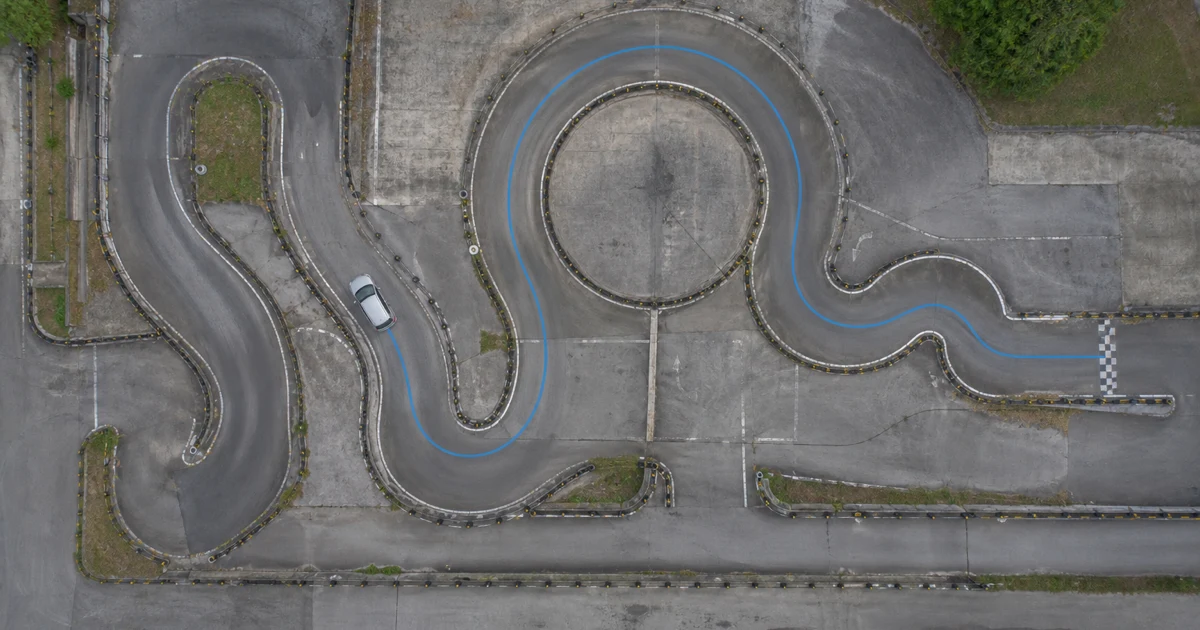 A training car following a curved driving course with a loop and finish line